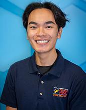 Peer mentor, Mickael Agustin, smiling against blue background